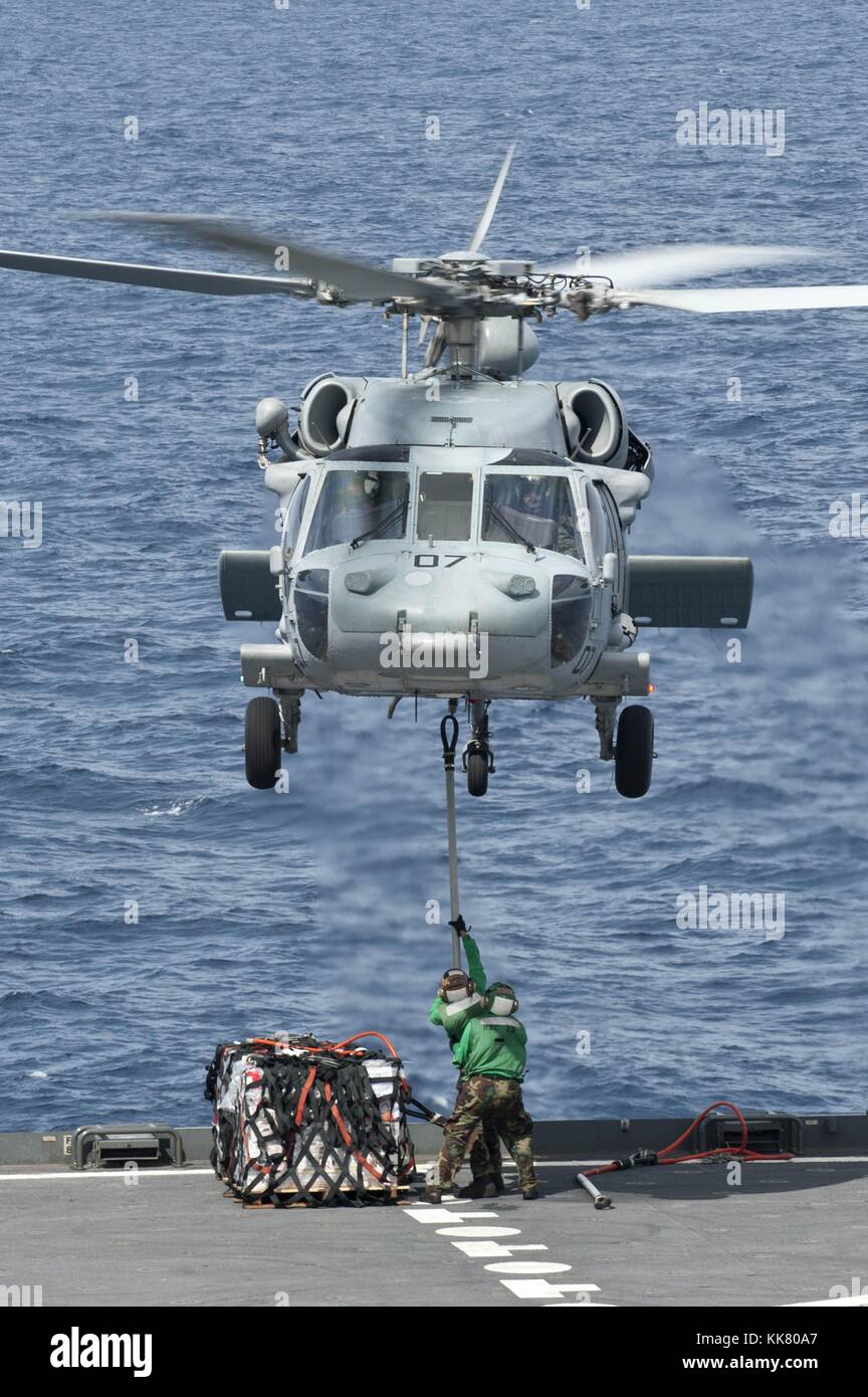 Un MH-60S Sea Hawk elicottero dall'isola dei Cavalieri di elicottero mare squadrone di combattimento HSC 25 solleva le forniture dal fiocco del militare Sealift il comando di carichi secchi e munizioni nave USNS Amelia Earhart T-AKE 6 prima di consegnarla alla portaerei USS George Washington CVN 73 durante un rifornimento in mare oceano Pacifico, 2012. Immagine cortesia la comunicazione di massa specialista di terza classe Paul Kelly/US Navy. Foto Stock