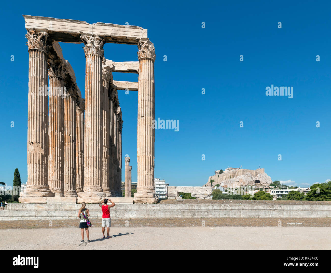 Paio di fronte al Tempio di Zeus Olimpio (Olympeion) con l'Acropoli in background, Atene, Grecia Foto Stock