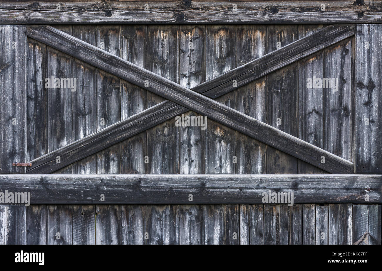 Strisce di legno texture da vecchio weathered plance. vintage gate rurale di un fienile da schede sbiadite con croce di listelli. Foto Stock