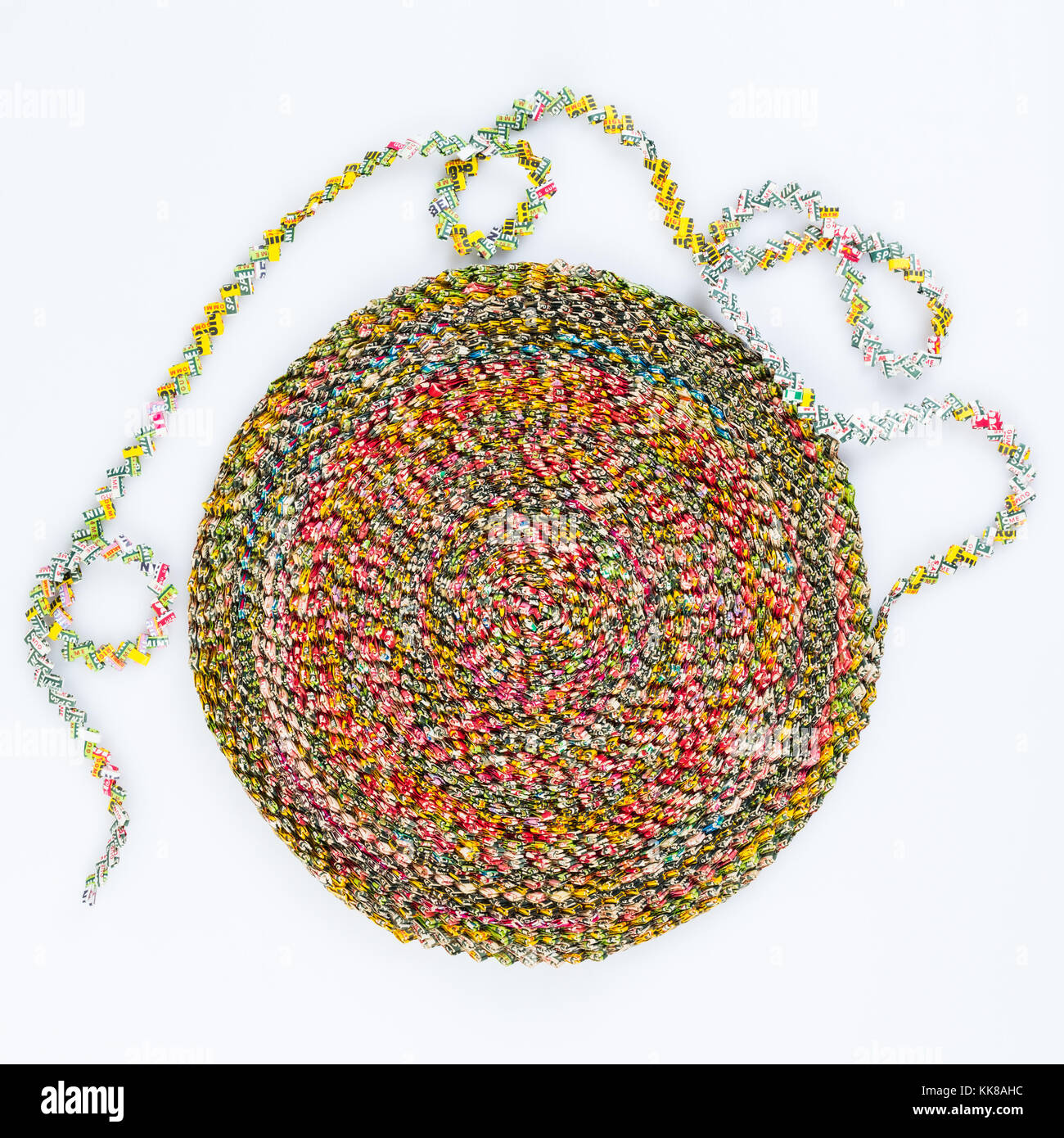 Gomma riciclata di involucri, piegato e tessuto e in procinto di essere incollato in un round tappetino decorativo. Foto Stock