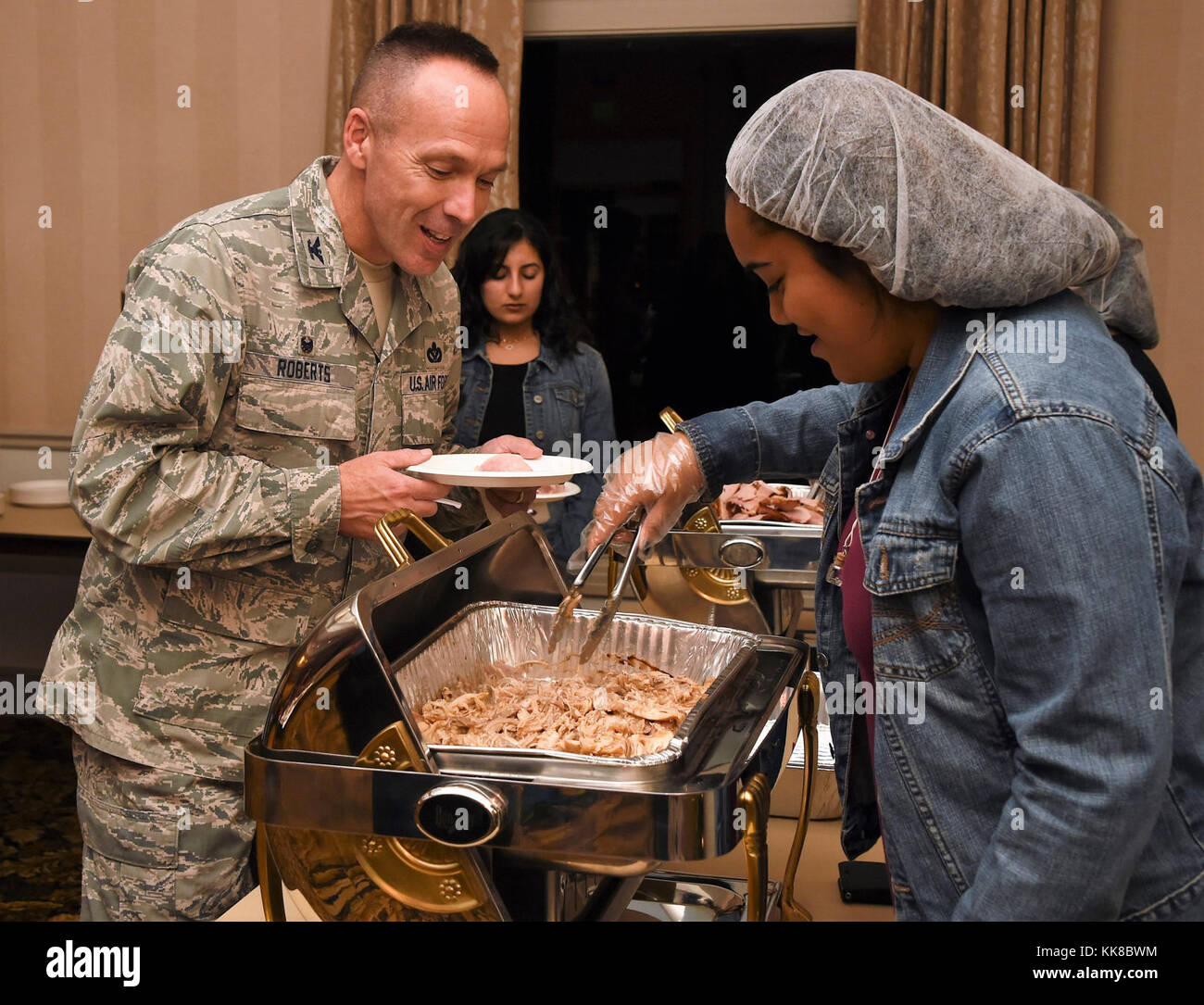 La 61aria Gruppo di base a Los Angeles Air Force Base ha ospitato la vacanza annuale festa di famiglia e uno speciale riconoscimento del volontariato presso il Fort MacArthur Community Center di San Pedro in California Nov 16, 2017. Col Charles Roberts, 61st Air Base Wing Commander, ottiene alcuni grub. Durante il pasto, comandante Jerome Ginsberg è stato riconosciuto per i suoi diciassette anni di lavoro con i giovani militari- dependents come istruttore di arti marziali qui a LA AFB. (U.S. Air Force foto/Joseph M. Juarez Suor) Foto Stock