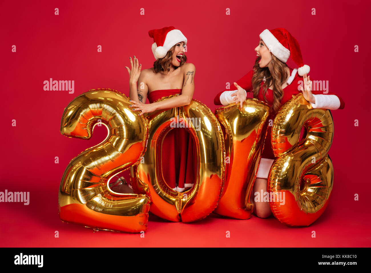 Immagini Di Natale Ragazze.Ritratto Di Entusiasti Belle Ragazze In Abiti Di Natale In Posa Con 2018 Color Oro Palloncini Numero Isolate Su Sfondo Rosso Foto Stock Alamy