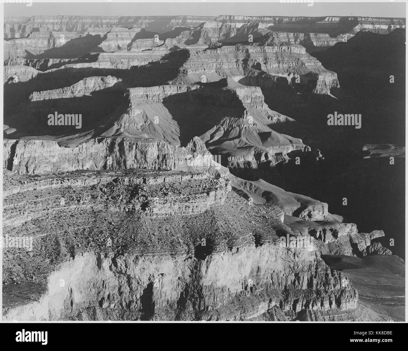 Fotografia in bianco e nero, visualizzare ombre scure a destra, alto orizzonte, con la dizione "Parco Nazionale del Grand Canyon', di Ansel Adams, da fotografie di parchi e monumenti nazionali, Arizona, Stati Uniti, 1941. Foto Stock