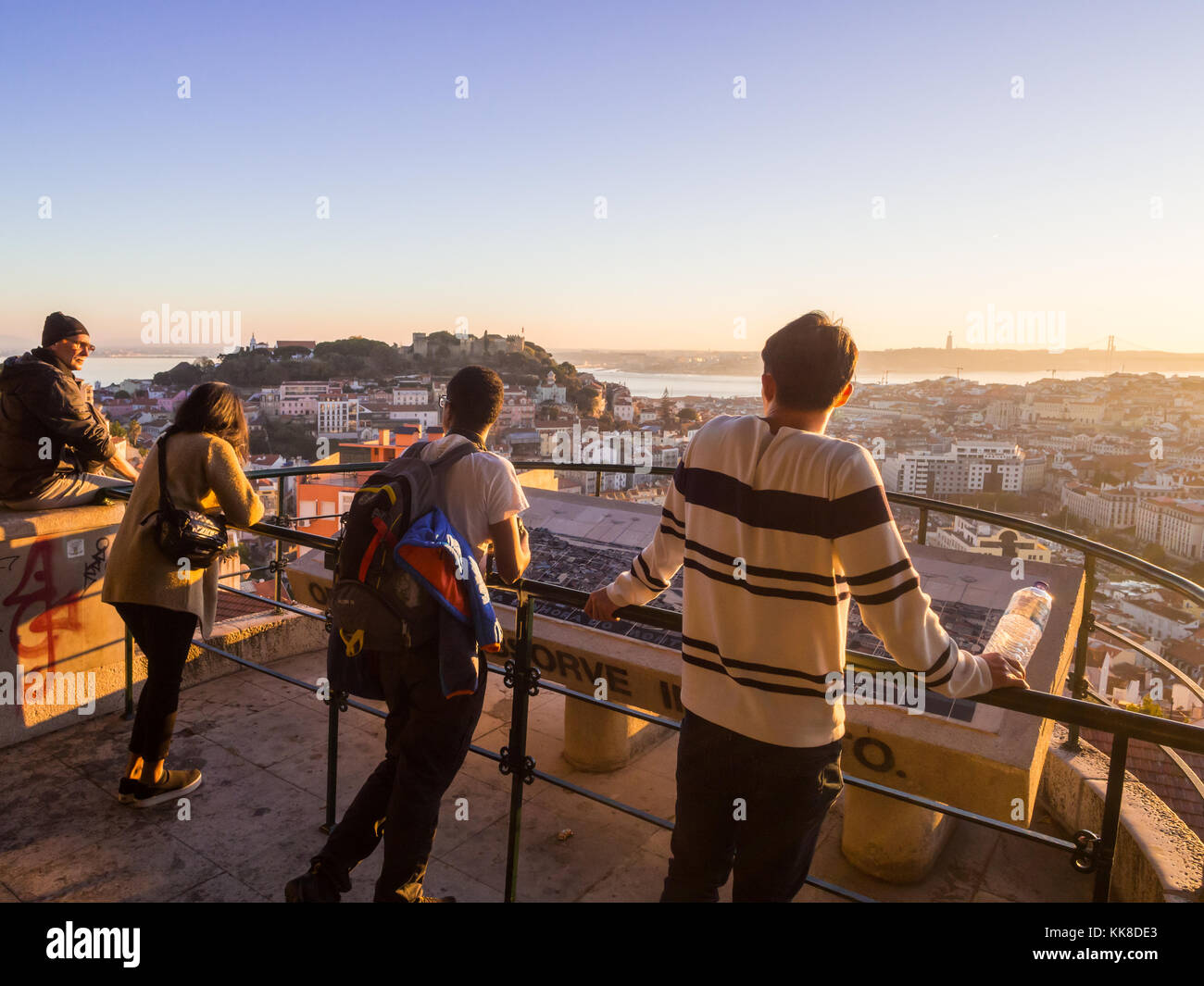 LISBONA, PORTOGALLO - 19 NOVEMBRE 2017: Turisti al belvedere di nostra Signora della collina, guardando il paesaggio urbano di Lisbona al tramonto. Foto Stock