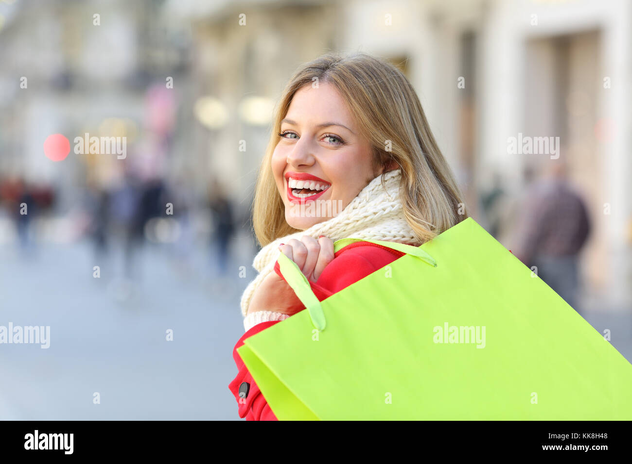 Vista posteriore ritratto di una shopper vuoto di contenimento delle borse per lo shopping a piedi sulla strada Foto Stock