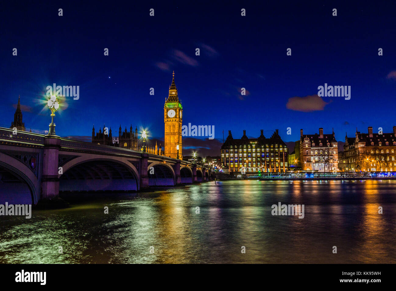 Un famoso punto di riferimento, la torre dell'orologio del Big ben di notte, presa dal lato sud del Tamigi nel centro di Londra. Foto Stock