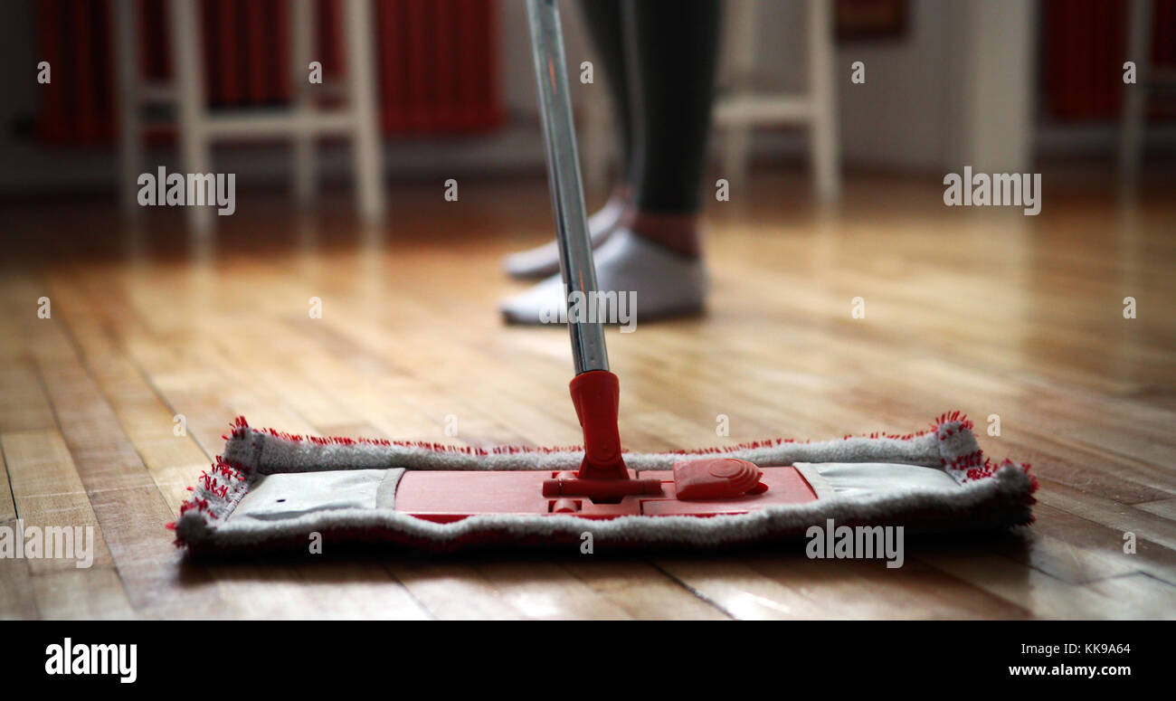 Donna che utilizza il mop cleaner per fare i lavori di casa più veloce Foto Stock