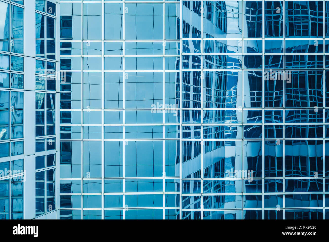 Architettura moderna frammento astratto, pareti di vetro e acciaio con riflessi di cielo blu Foto Stock