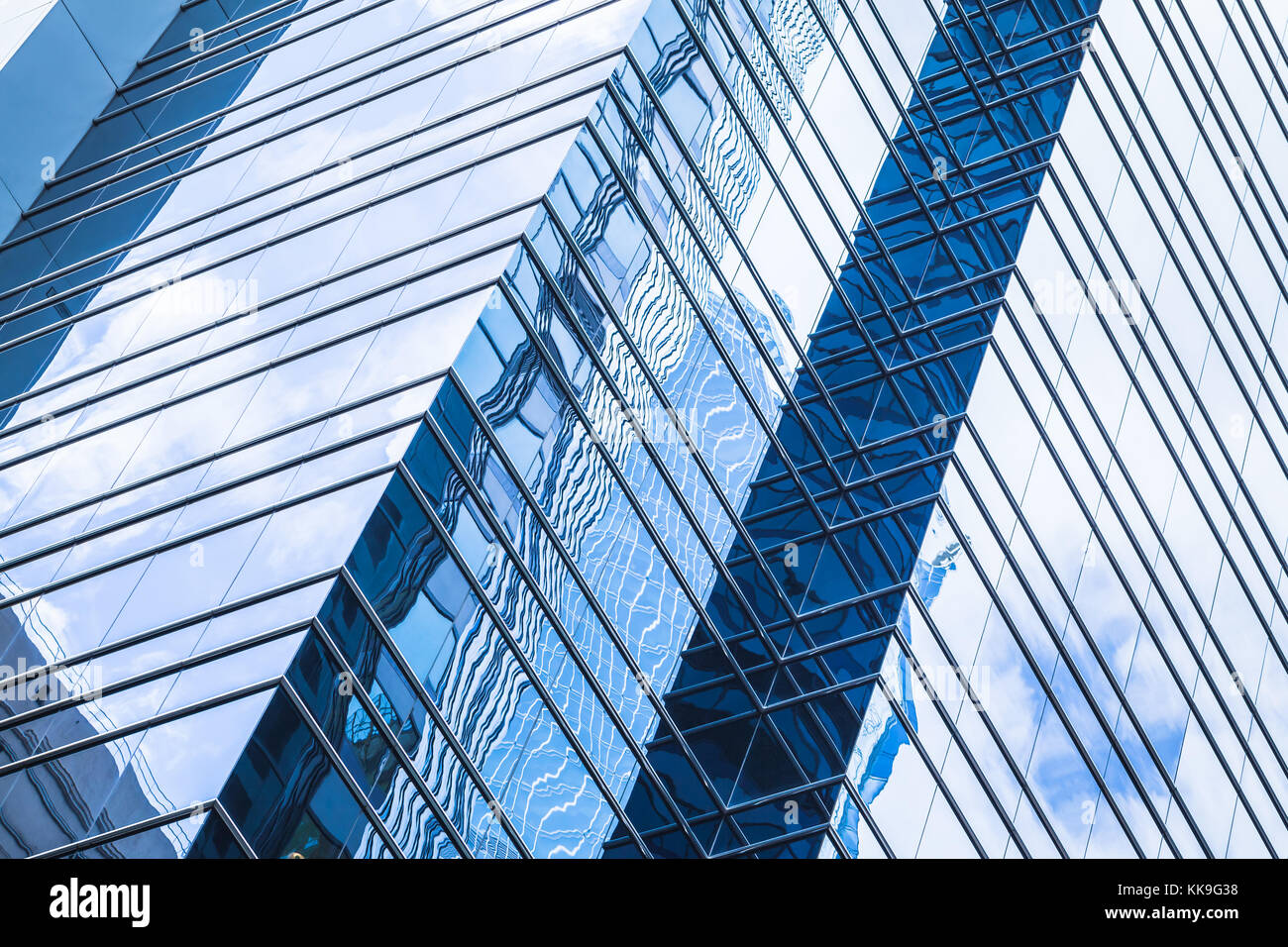 Moderna architettura aziendale, frammento astratto, pareti di vetro e acciaio con riflessi di cielo blu Foto Stock