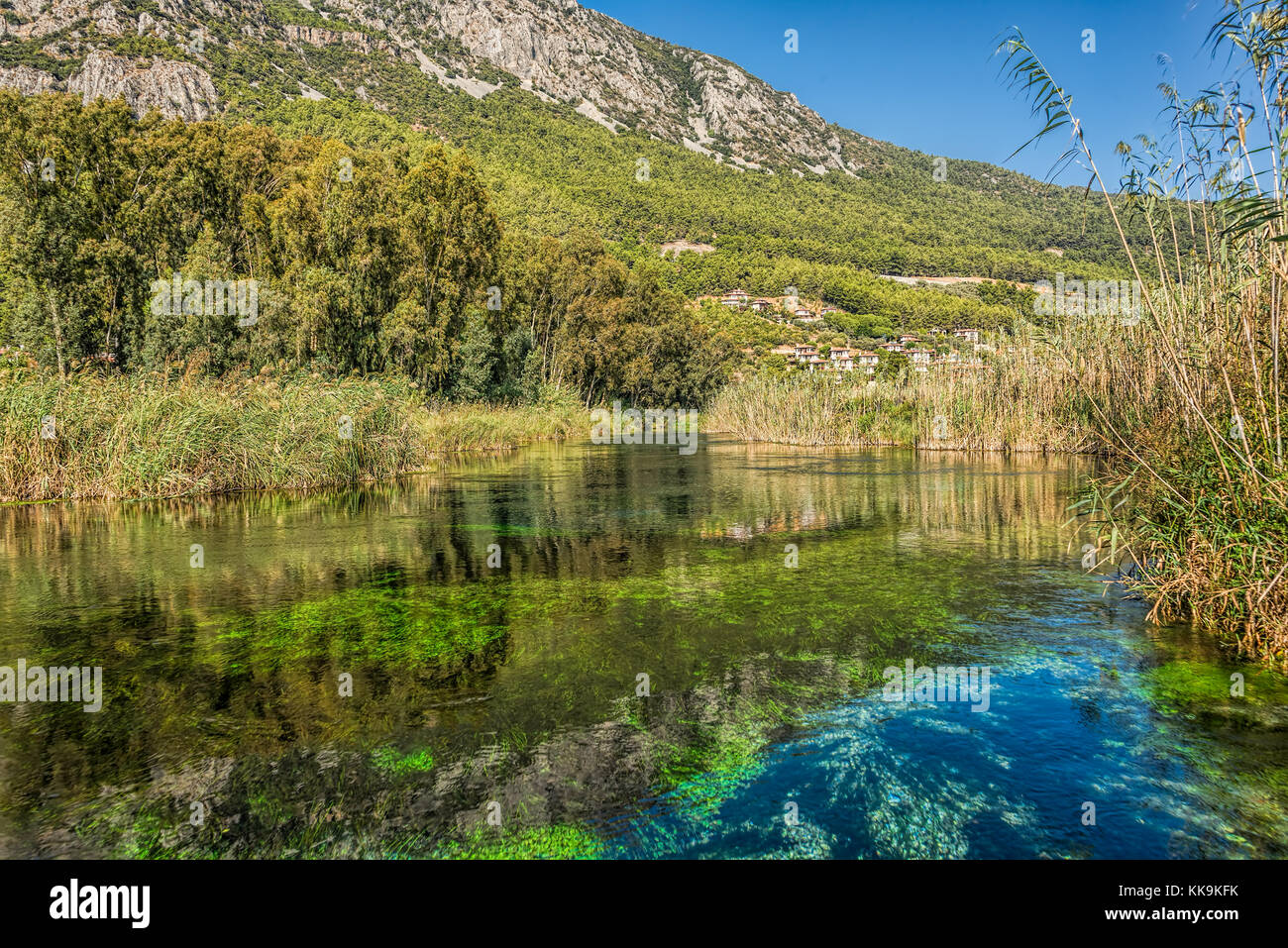 Crystal Clear, acquario come acqua il flusso sotto un cielo blu chiaro, akyaka, mugla, Turchia Foto Stock