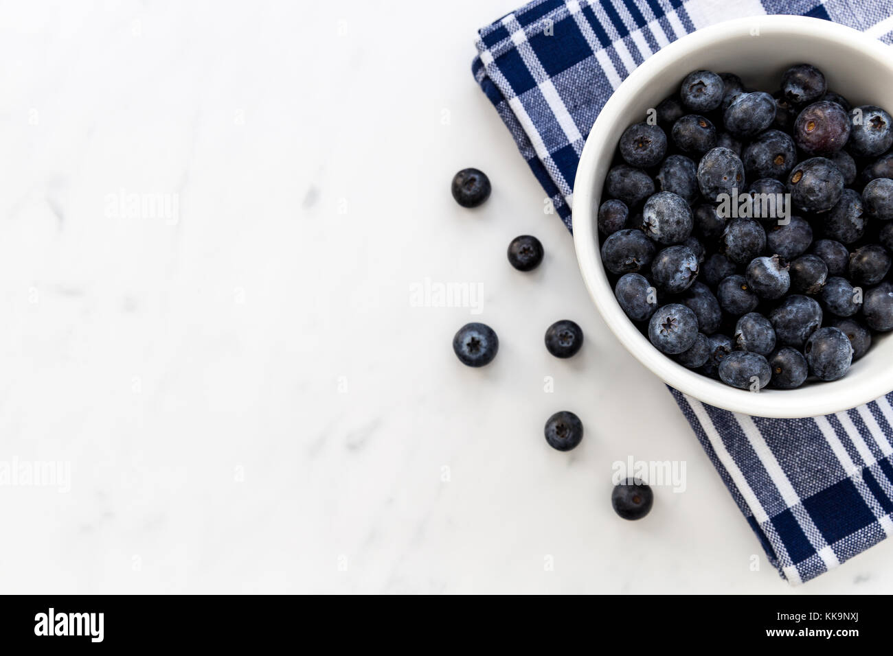 Ciotola di mirtilli freschi di frutta bianca su sfondo marmo Foto Stock