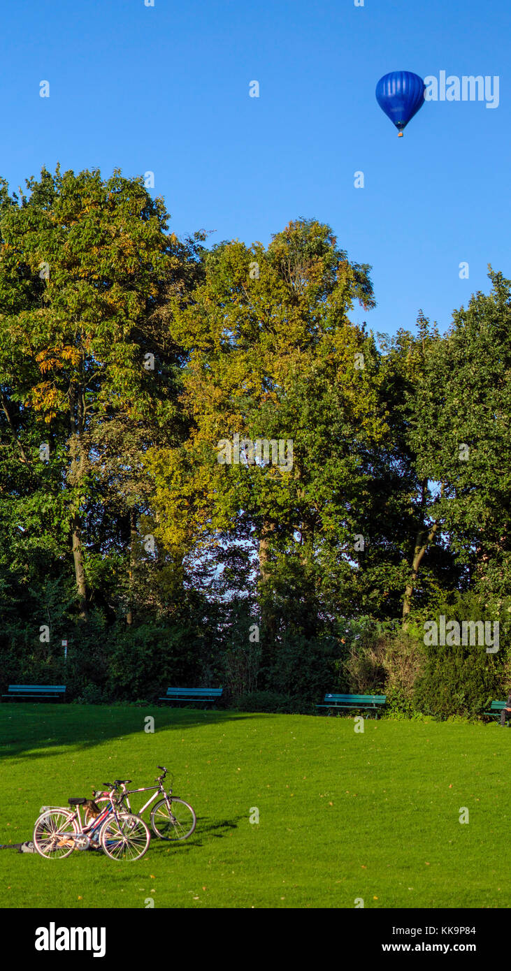 Belgio, bruges pomeriggio nel parco, matura in appoggio sull'erba dopo escursioni in bicicletta. Foto Stock