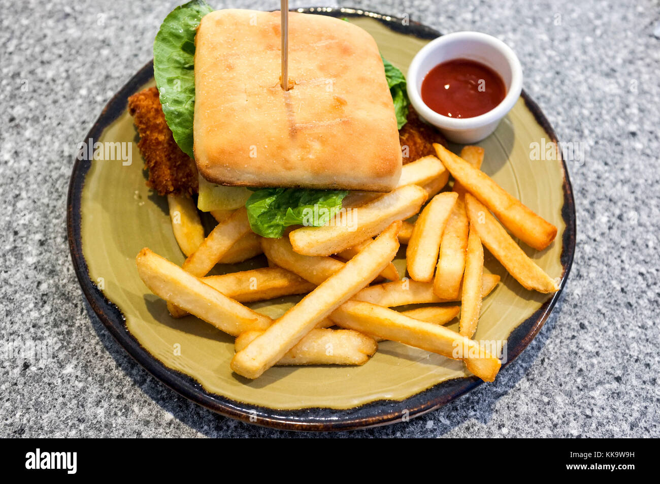 Una cotoletta di pollo burger con patatine e salsa di pomodoro. Foto Stock