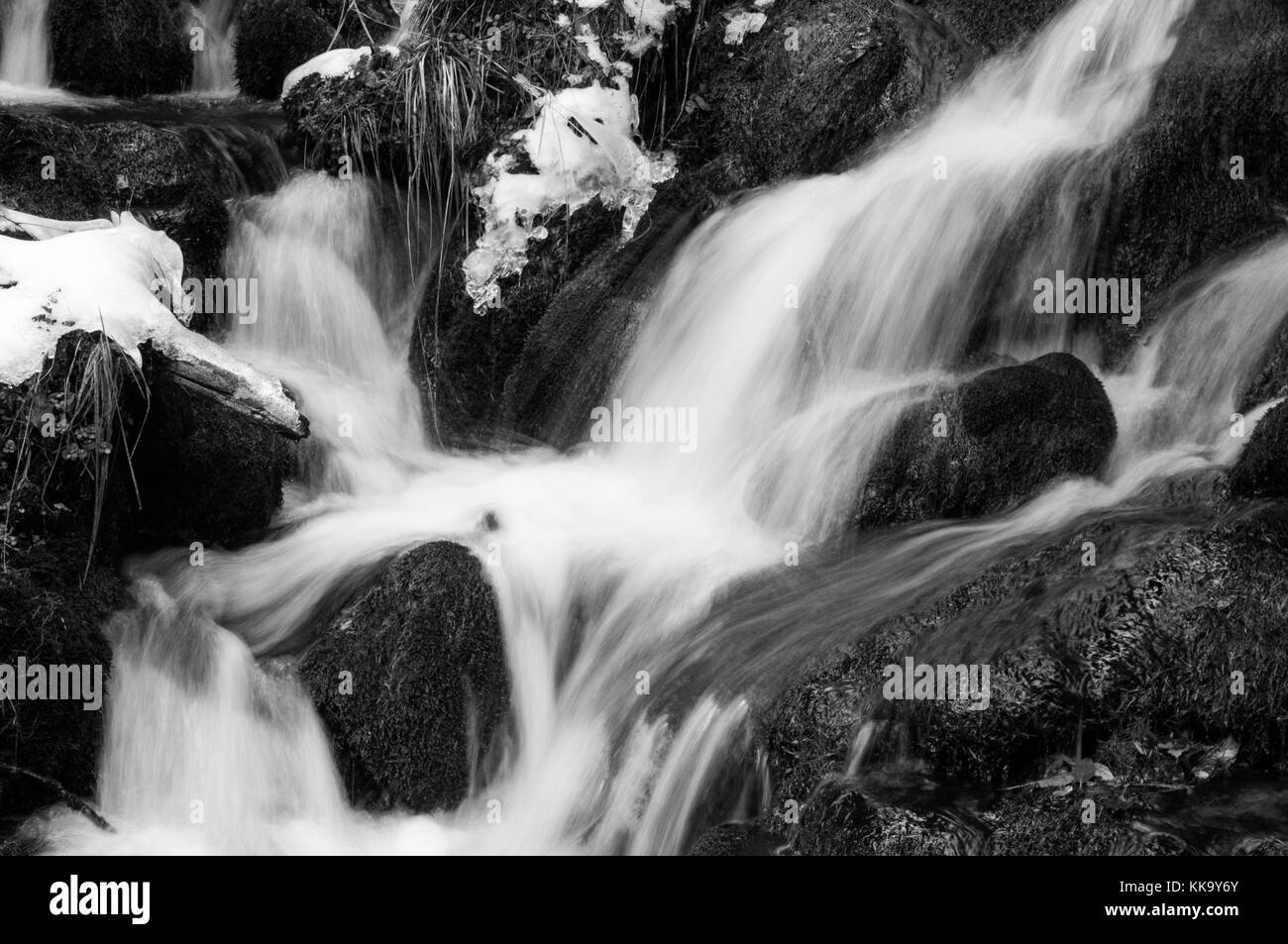 Nero e withe colpo di freddo mountain creek correre verso il basso attraverso i massi (lunga esposizione) Foto Stock