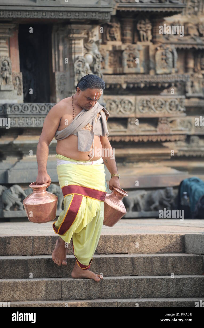 Mattina in Chenna Keshava Vishnu Temple - Sacerdote con lota kalash pot facendo offerte - Priester Kuferkrug mit Wasser beim holen Foto Stock