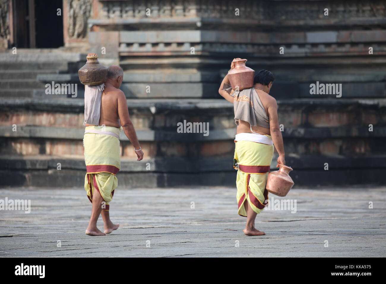 Mattina in Chenna Keshava Vishnu Temple - Sacerdote con lota kalash pot facendo offerte - Priester Kuferkrug mit Wasser beim holen Foto Stock