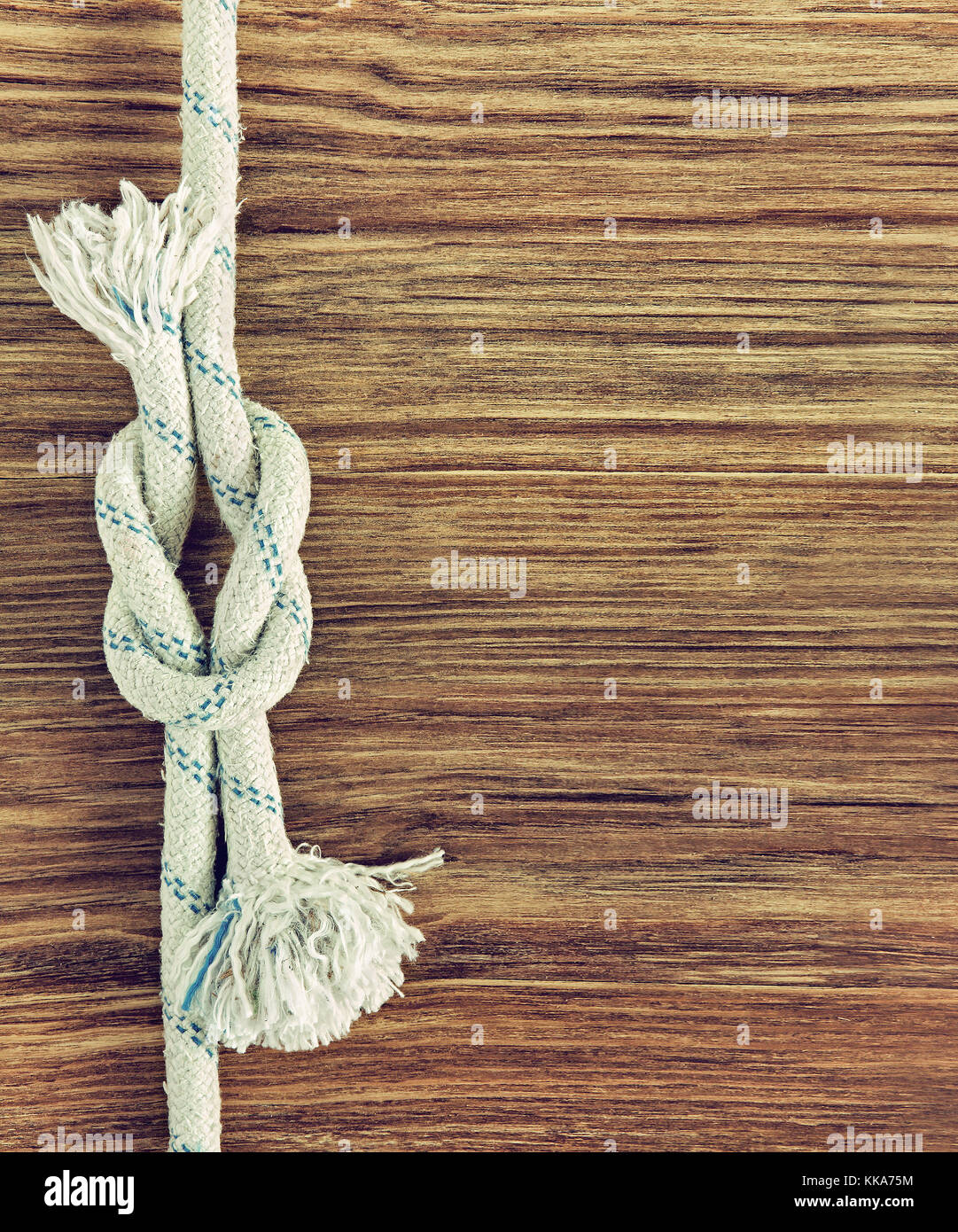 Bianco e corda nautica reef nodo su grunge sfondo di legno.lo spazio vuoto per il testo. Foto Stock