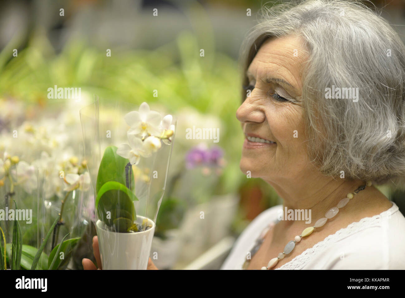 Donna anziana la scelta di fiori Foto Stock