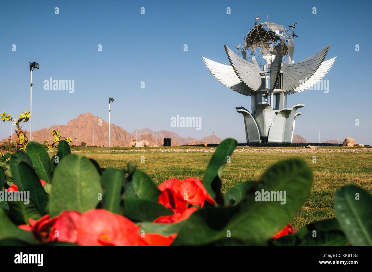 Sharm el Sheikh, Sinai, Egitto - 12 Novembre 2017: Monumento Piazza Della Pace sullo sfondo di fiori di colore rosso Foto Stock