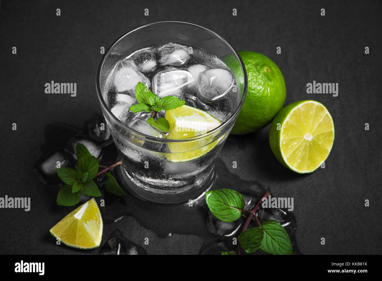 Un bicchiere di cocktail mojito con calce e menta su una pietra grigia, sfondo vuoto posto pulito per il testo Foto Stock