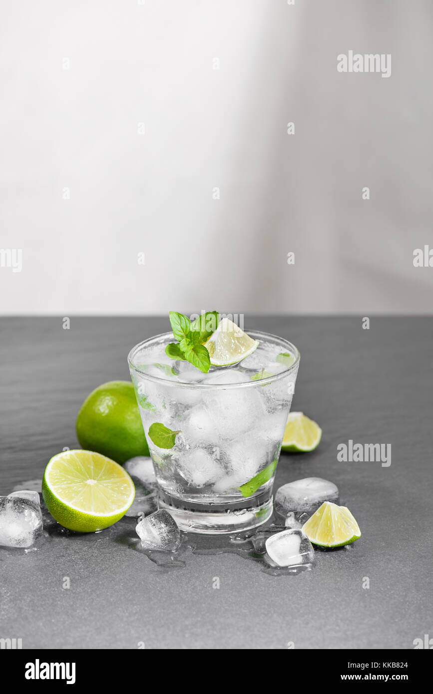 Un bicchiere di cocktail mojito con calce e menta su una pietra grigia, sfondo vuoto posto pulito per il testo Foto Stock