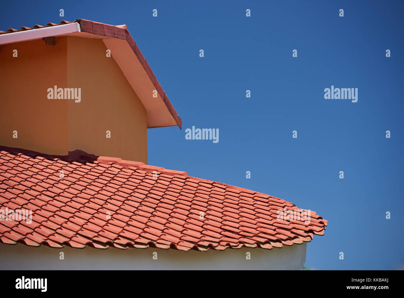 Casa Rossa tetto sul soleggiato blu sfondo luminoso Foto Stock