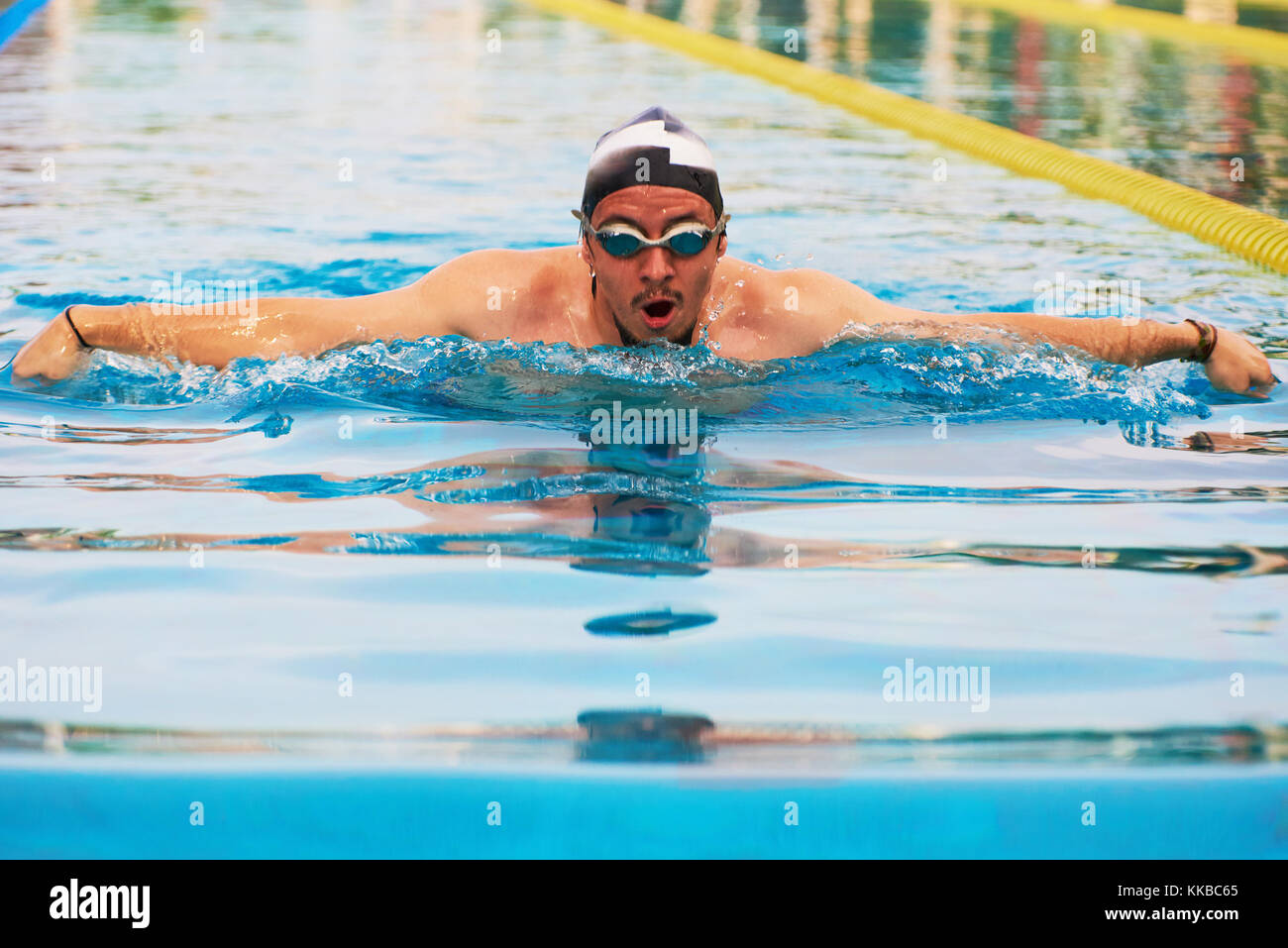 Close-up del nuotatore uomo in blu piscina esterna di acqua Foto Stock