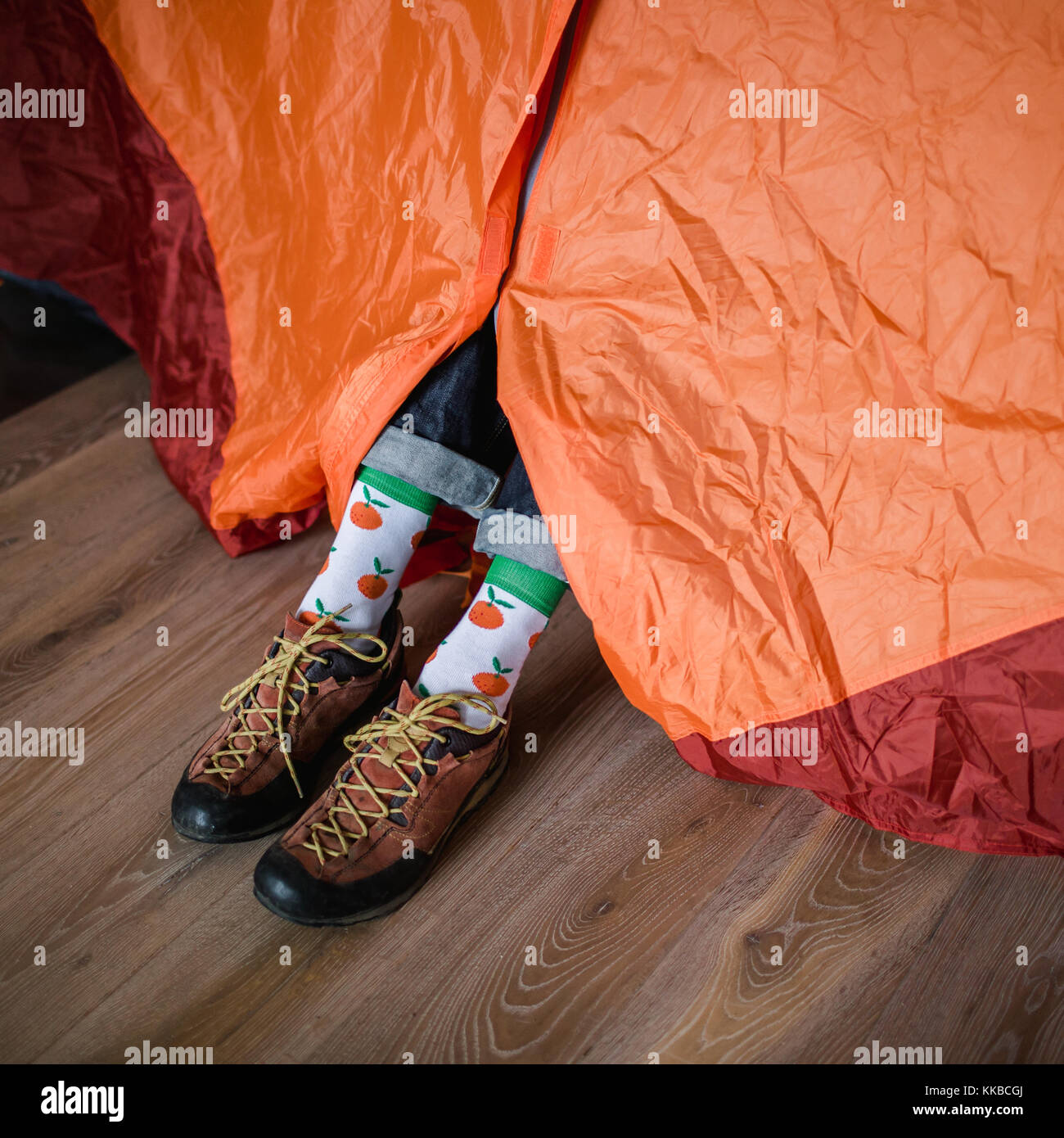 Piedi in happy socks. l uomo è rilassante vicino alla tenda e riscaldare i suoi piedi in happy socks. Foto Stock