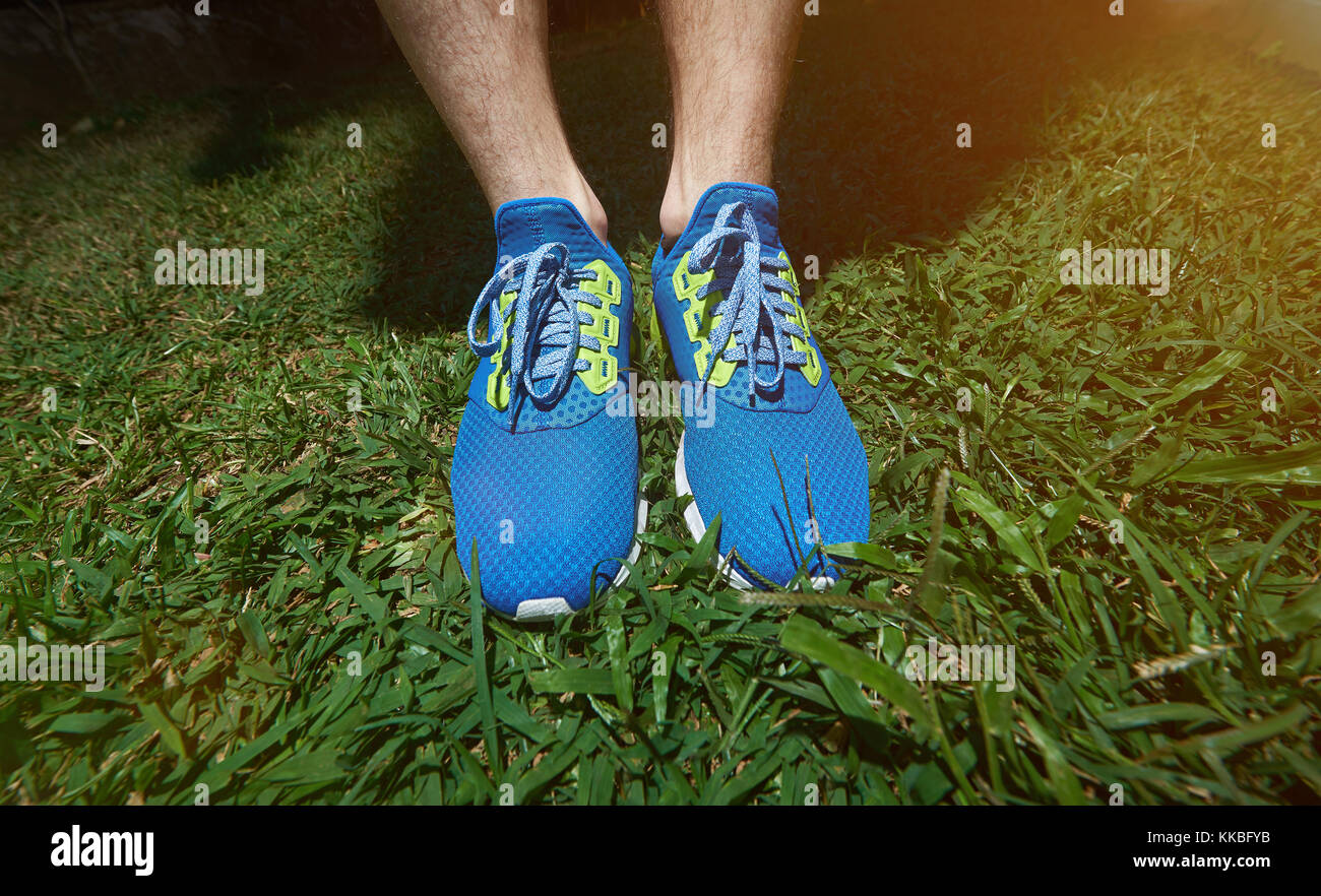Scarpe running close-up permanente sulla erba verde dello sfondo. estate esercizio jog Foto Stock