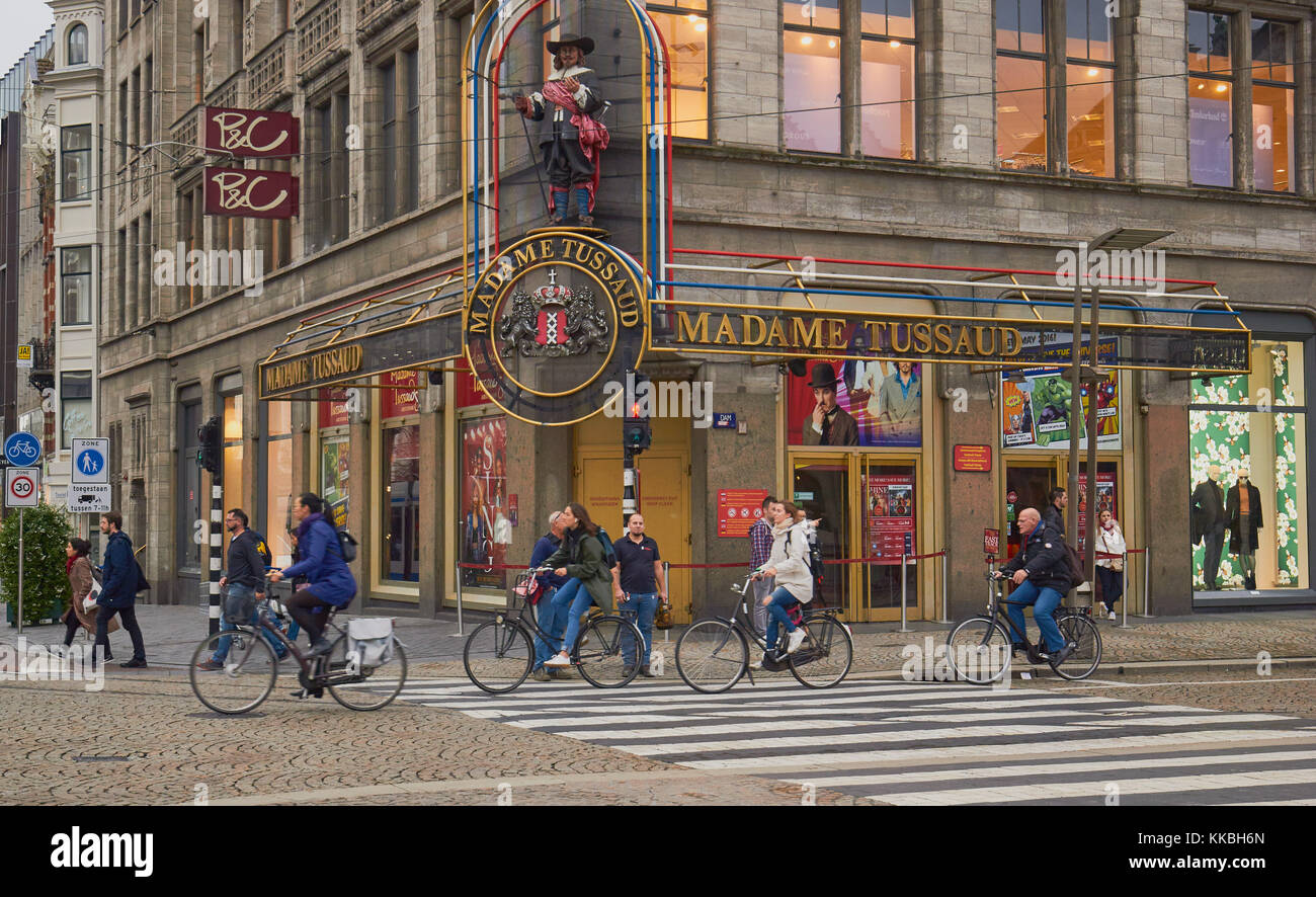 I ciclisti passando il Madame Tussauds di Amsterdam e Piazza Dam, Amsterdam, Olanda. Foto Stock