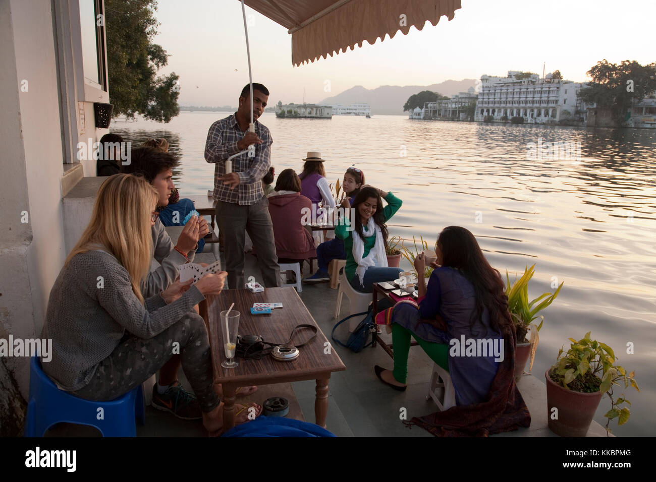I clienti seduti sulla terrazza sul lago a Jheel Zenzero del Coffee Bar & Bakery, da Chandpol, Udaipur, Rajasthan, India Foto Stock
