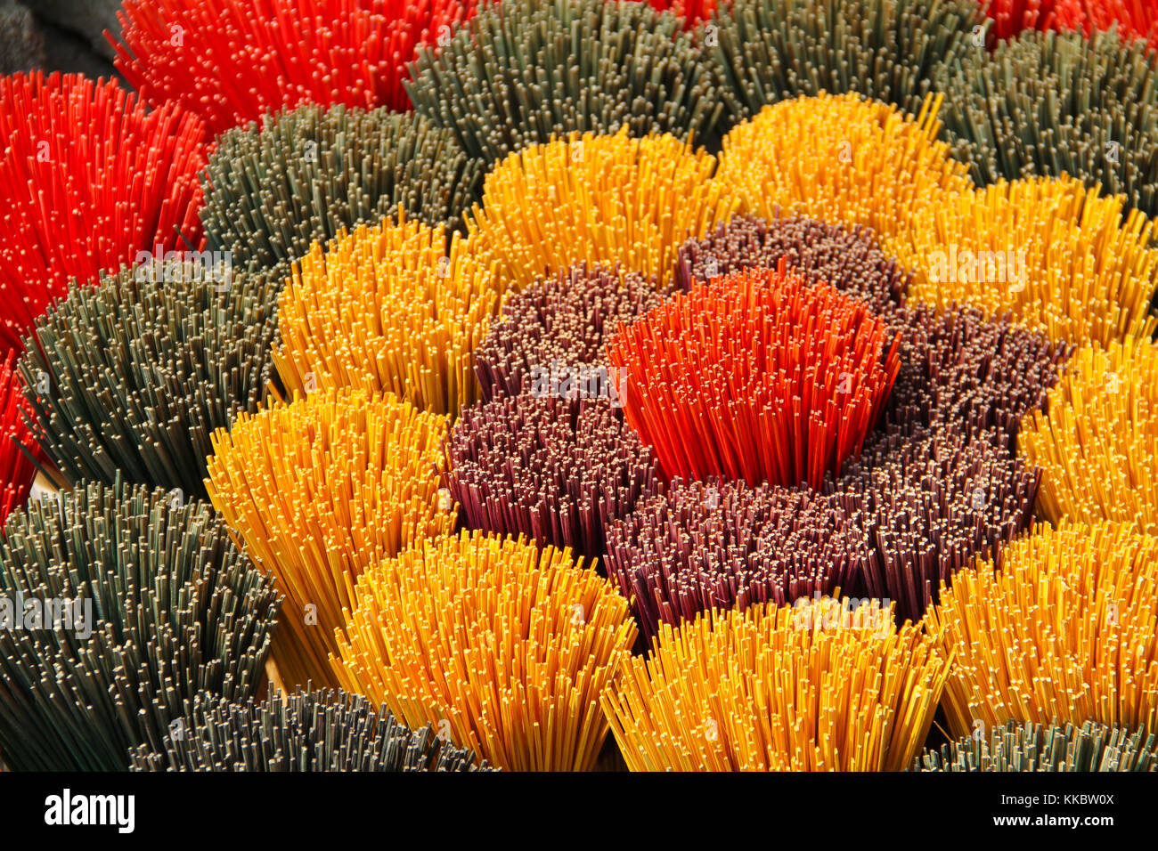 Colori diversi bastoncini di incenso in vendita, Vietnam Foto Stock