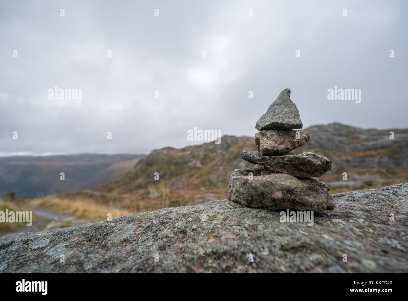 Equilibrato Zen piccolo mucchio di pietre impilate su un percorso a piedi partendo sulla sommità del monte Ulriken a Bergen, Norvegia Foto Stock