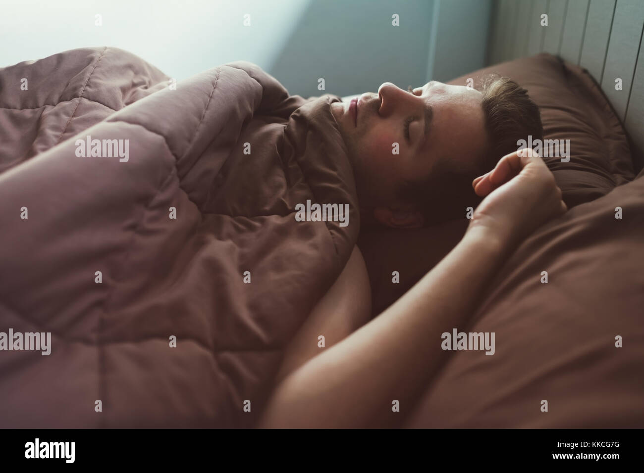 Uomo caucasico napping in letto la mattina. Foto Stock