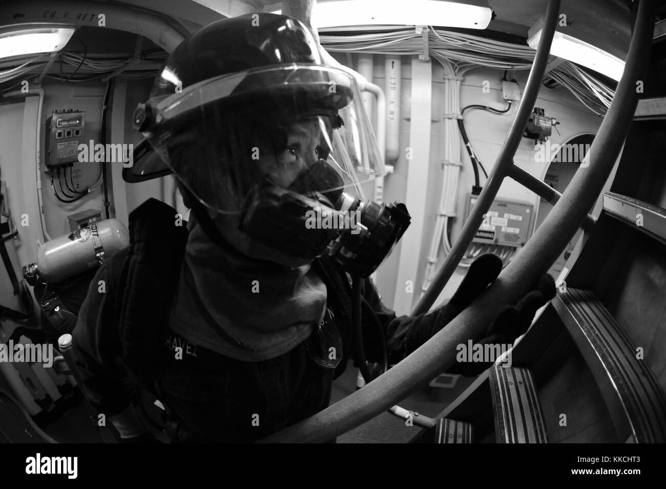 Il tecnico meccanico Isabel Chavez, assegnato al cacciatorpediniere missilistico guidato classe Arleigh burke USS McCampbell DDG 85, passa un tubo di fuoco ai marinai che combattono un incendio simulato durante un'esercitazione di controllo dei danni, Sea of Japan. Per gentile concessione di Seaman Declan Barnes/US Navy, specialista della comunicazione di massa. 2012. Foto Stock