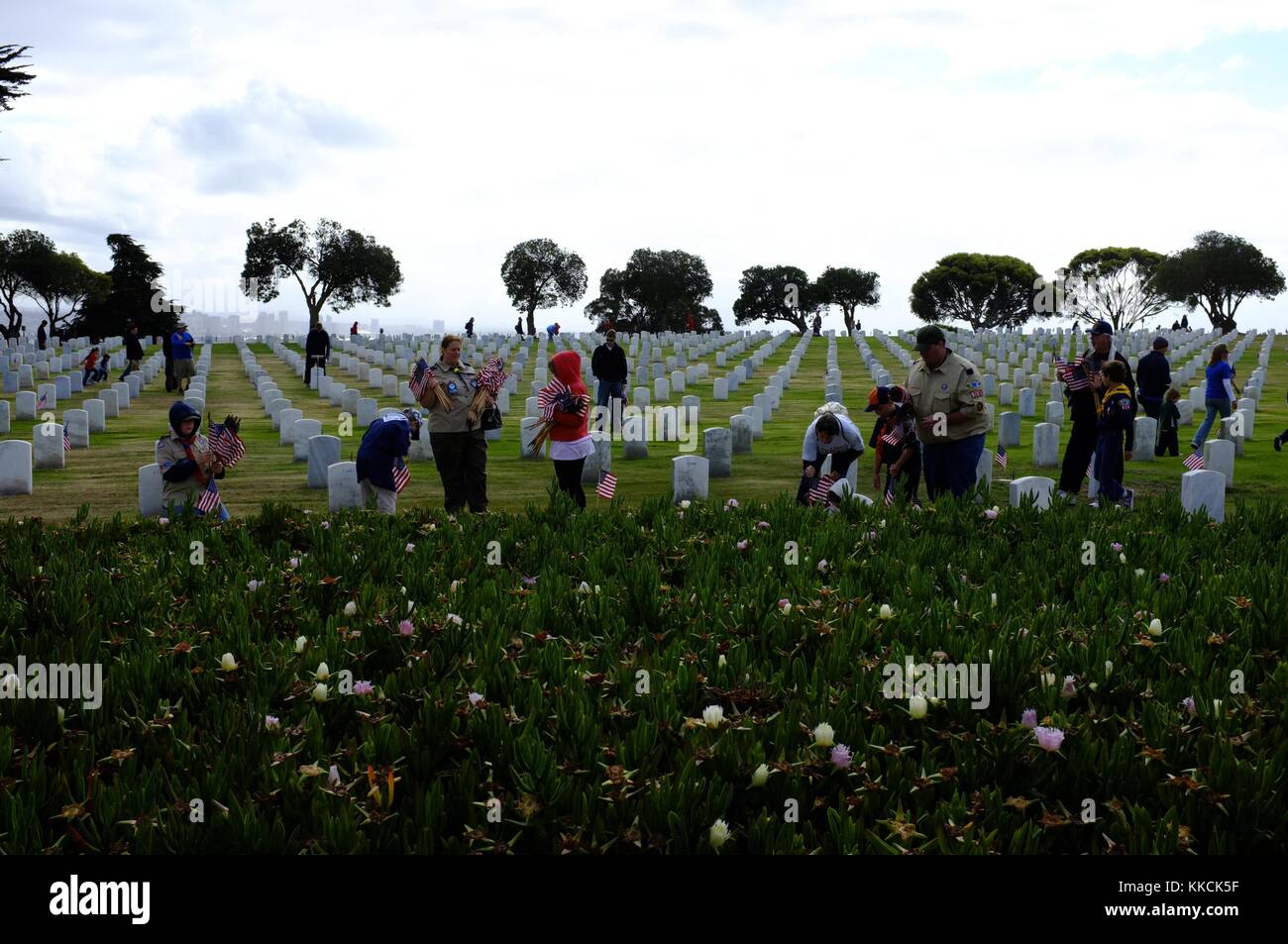 Boy Scout luogo bandiere sulle lapidi a Ft Rosecrans cimitero in preparazione per il Memorial Day holiday, San Diego. Immagine cortesia la comunicazione di massa Specialist 1a classe Brian P. Biller/US Navy, 1205. Foto Stock