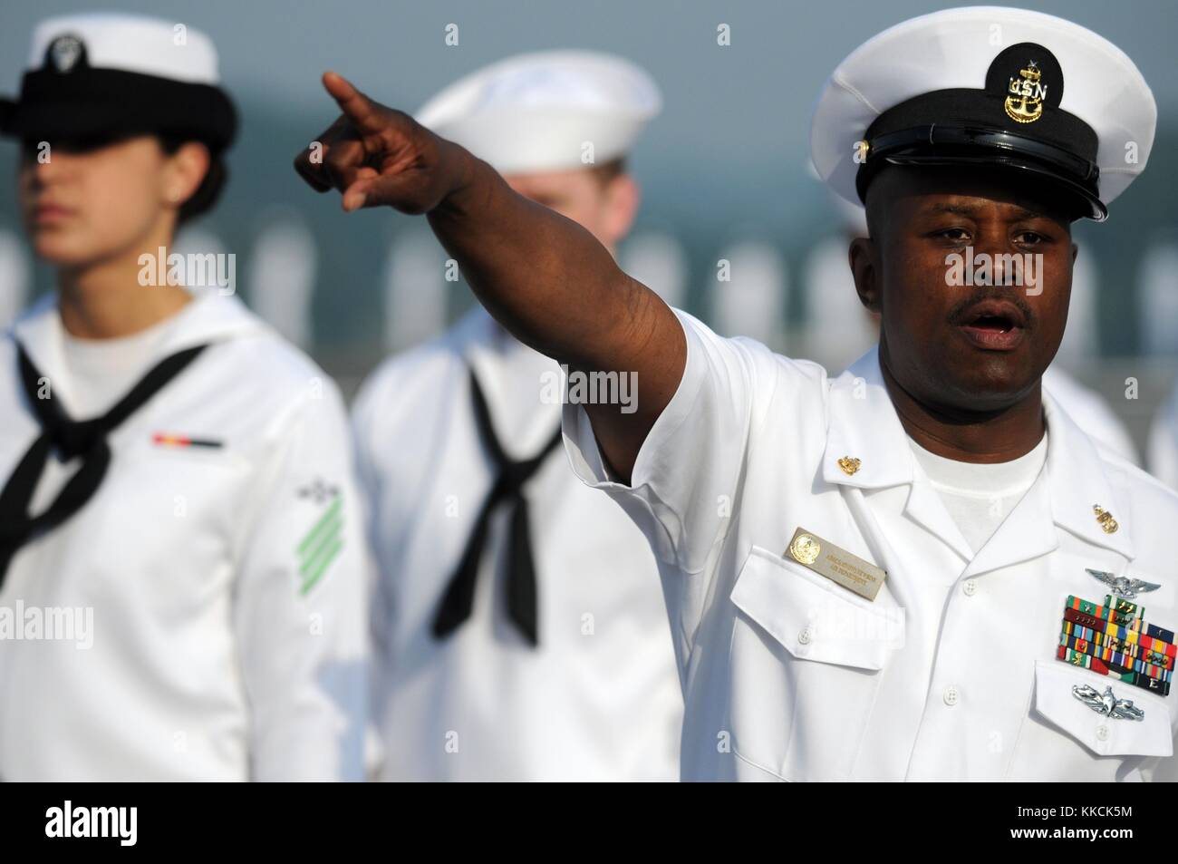 Senior Chief Aviation Nostromi Mate manipolazione Glen Newbins dirige i marinai in preparazione all'uomo le rotaie del Giappone-basato, Nimitz-class portaerei USS George Washington CVN 73 prima di uscire Yokosuka, Giappone, 120526-N-Ww409-053 Yokosuka, Giappone. Immagine cortesia la comunicazione di massa Specialist 1a classe Jennifer A. Villalovos/US Navy, 1205. Foto Stock