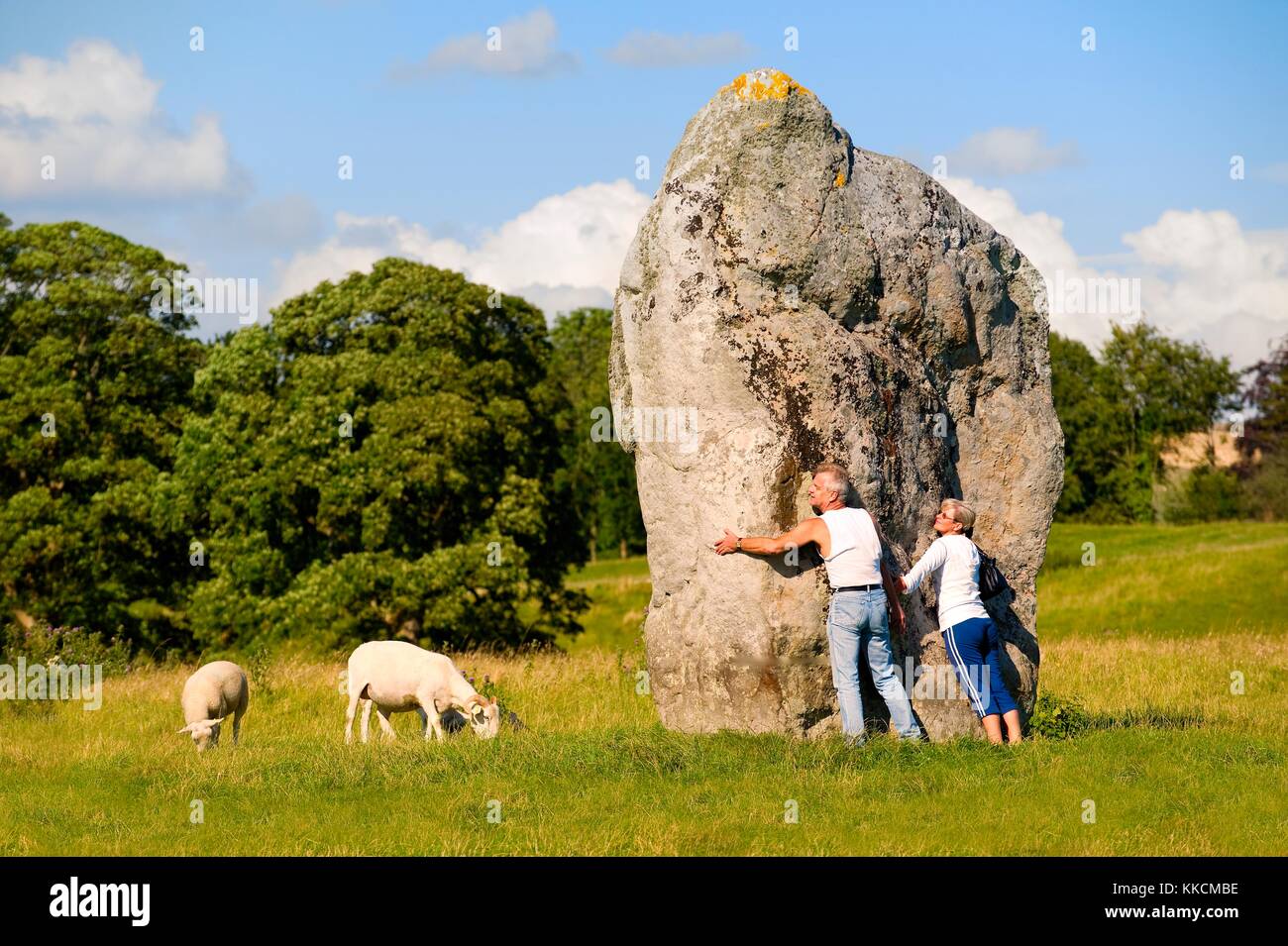 Ad Avebury henge neolitica e circoli di pietre, Wiltshire, Inghilterra. 5600 anni. Visitatori abbracciare la civiltà megalitica interna del cerchio del Sud Foto Stock