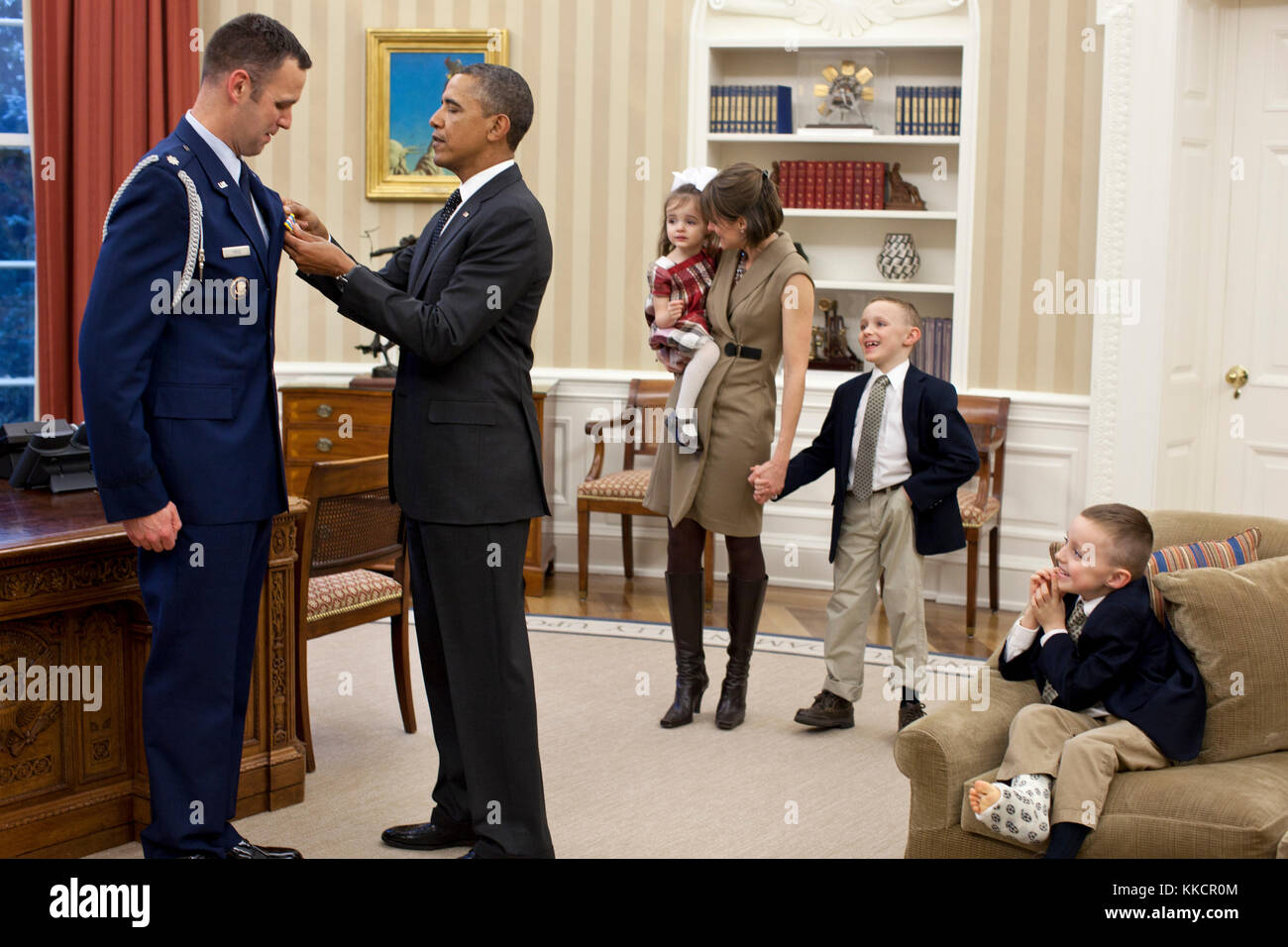 Membri della famiglia di prezzo guardare come il presidente Barack Obama presenta la difesa servizio superior medaglia a militare in partenza aide lt. col. sam prezzo nell'ufficio ovale, gen. 9, 2012. Foto Stock