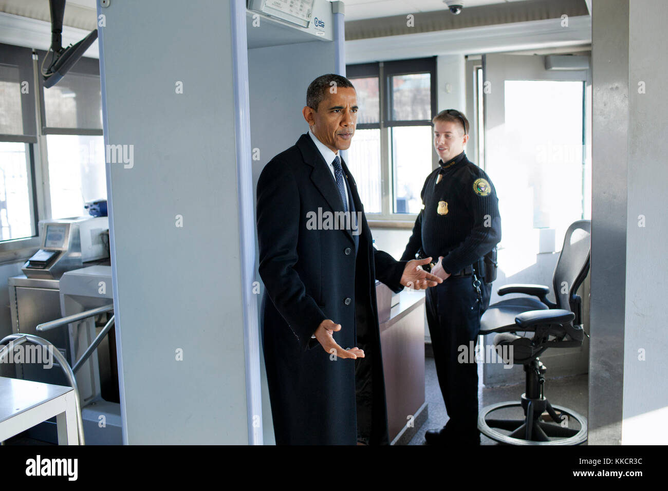 Il presidente Barack Obama parla al servizio segreto di divisione in uniforme ufficiali come egli cammina attraverso il magnetometro nel nordovest gatehouse alla Casa Bianca, dopo la sua visita a Blair House, dec. 9, 2011. Il presidente ha detto a un reporter come egli esce da gatehouse, "Volevo solo per vedere di che cosa era come arrivare qui'. Foto Stock