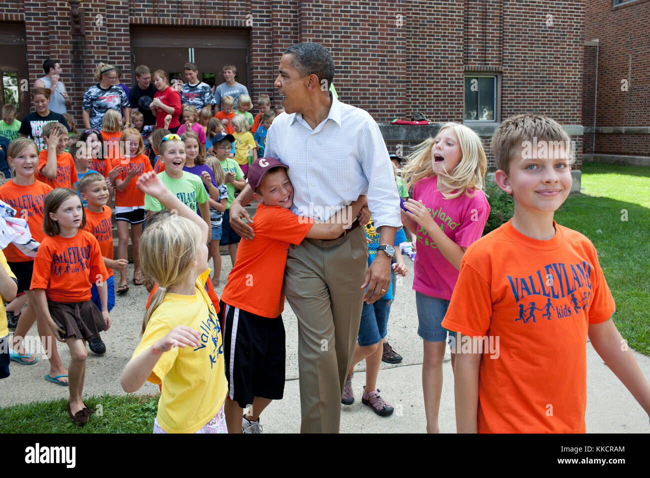 Il presidente Barack Obama saluta i bambini del programma estivo per bambini Valleyland al di fuori di una scuola a Chatfield, Minn., durante un tour di tre giorni in autobus nel Midwest, il 15 agosto 2011. Foto Stock