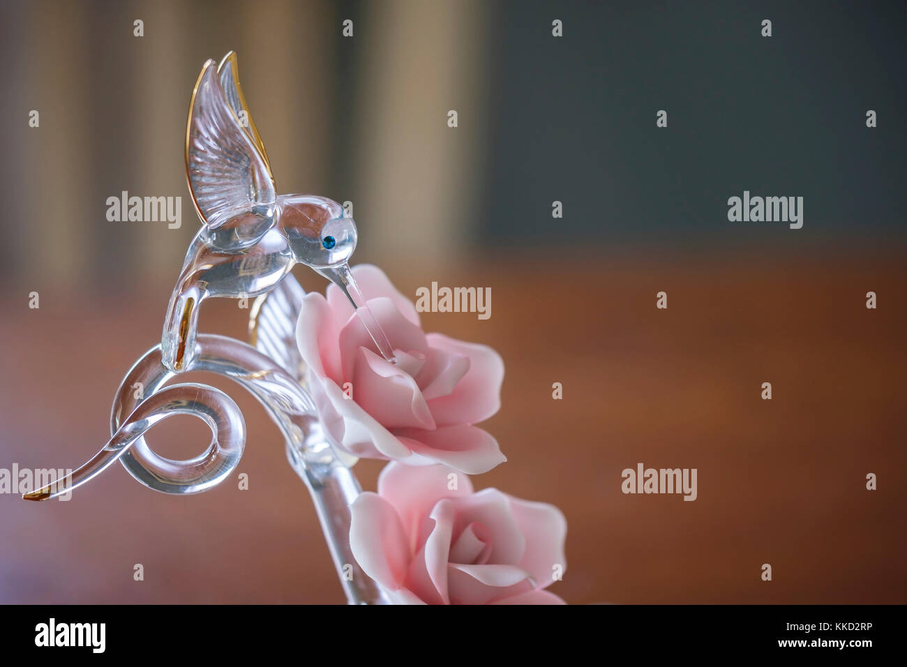 Un vetro arte figurina di un colibrì in rosa rose. Colibrì sono uccelli della famiglia Trochilidae, e sono nativi solo per le Americhe. Stati Uniti d'America. Foto Stock