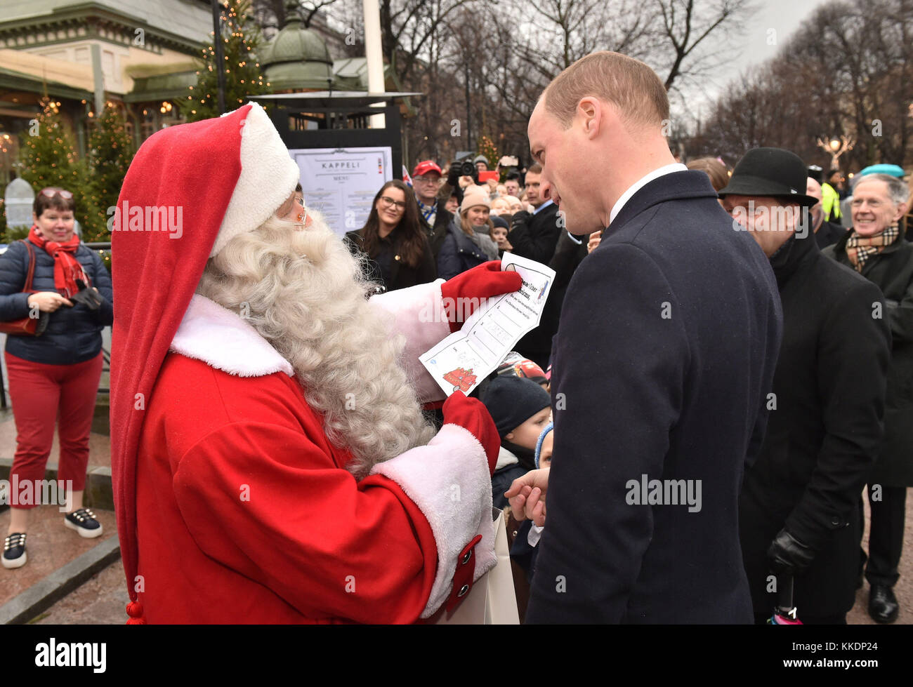 Il Duca di Cambridge mani Prince George Natale la lista dei desideri per un uomo vestito da Babbo Natale nella sua visita al parco Esplanade mercatino di Natale di Helsinki, nel secondo giorno della sua visita di Finlandia. Foto Stock