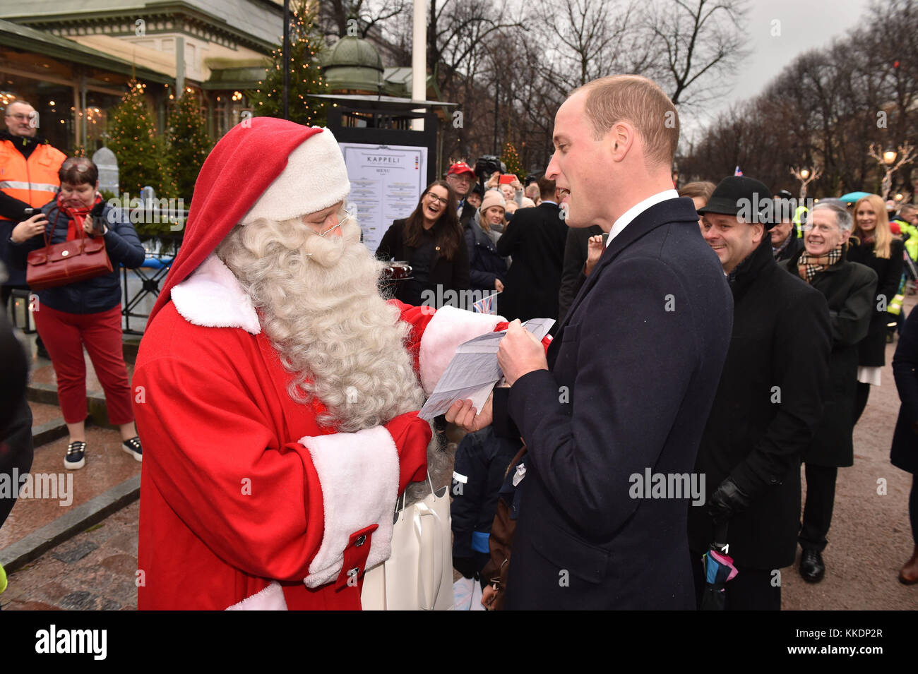 Il Duca di Cambridge mani Prince George Natale la lista dei desideri per un uomo vestito da Babbo Natale nella sua visita al parco Esplanade mercatino di Natale di Helsinki, nel secondo giorno della sua visita di Finlandia. Foto Stock