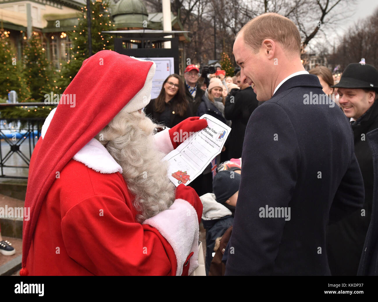 Il Duca di Cambridge mani Prince George Natale la lista dei desideri per un uomo vestito da Babbo Natale nella sua visita al parco Esplanade mercatino di Natale di Helsinki, nel secondo giorno della sua visita di Finlandia. Foto Stock