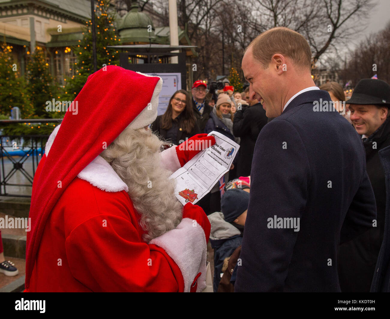 Il Duca di Cambridge mani Prince George Natale la lista dei desideri per un uomo vestito da Babbo Natale nella sua visita al parco Esplanade mercatino di Natale di Helsinki, nel secondo giorno della sua visita di Finlandia. Foto Stock
