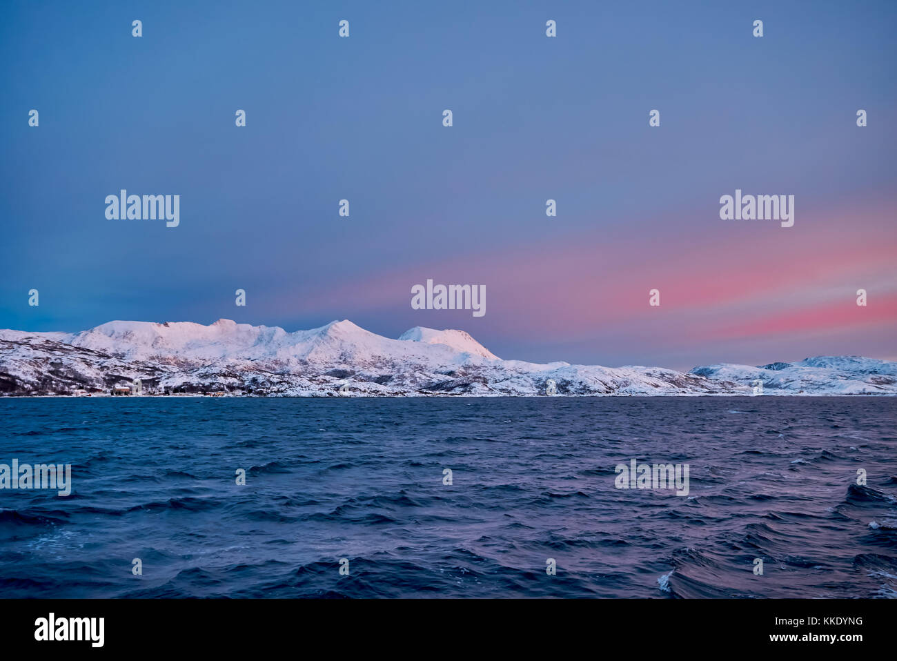 Alba sul fiordo con montagne coperte di neve e paesaggio invernale visto da sailship vicino a Tromso, Troms, Norvegia, Europa Foto Stock