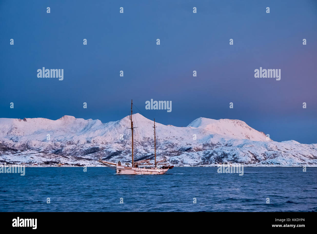 Alba sul fiordo con montagne coperte di neve e paesaggio invernale e sailship vicino a Tromso, Troms, Norvegia del nord, Europa Foto Stock