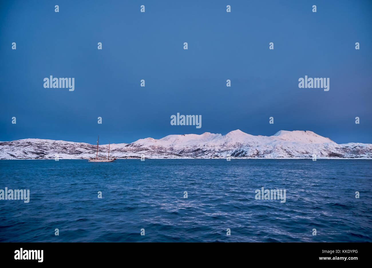 Alba sul fiordo con montagne coperte di neve e paesaggio invernale e sailship vicino a Tromso, Troms, Norvegia del nord, Europa Foto Stock