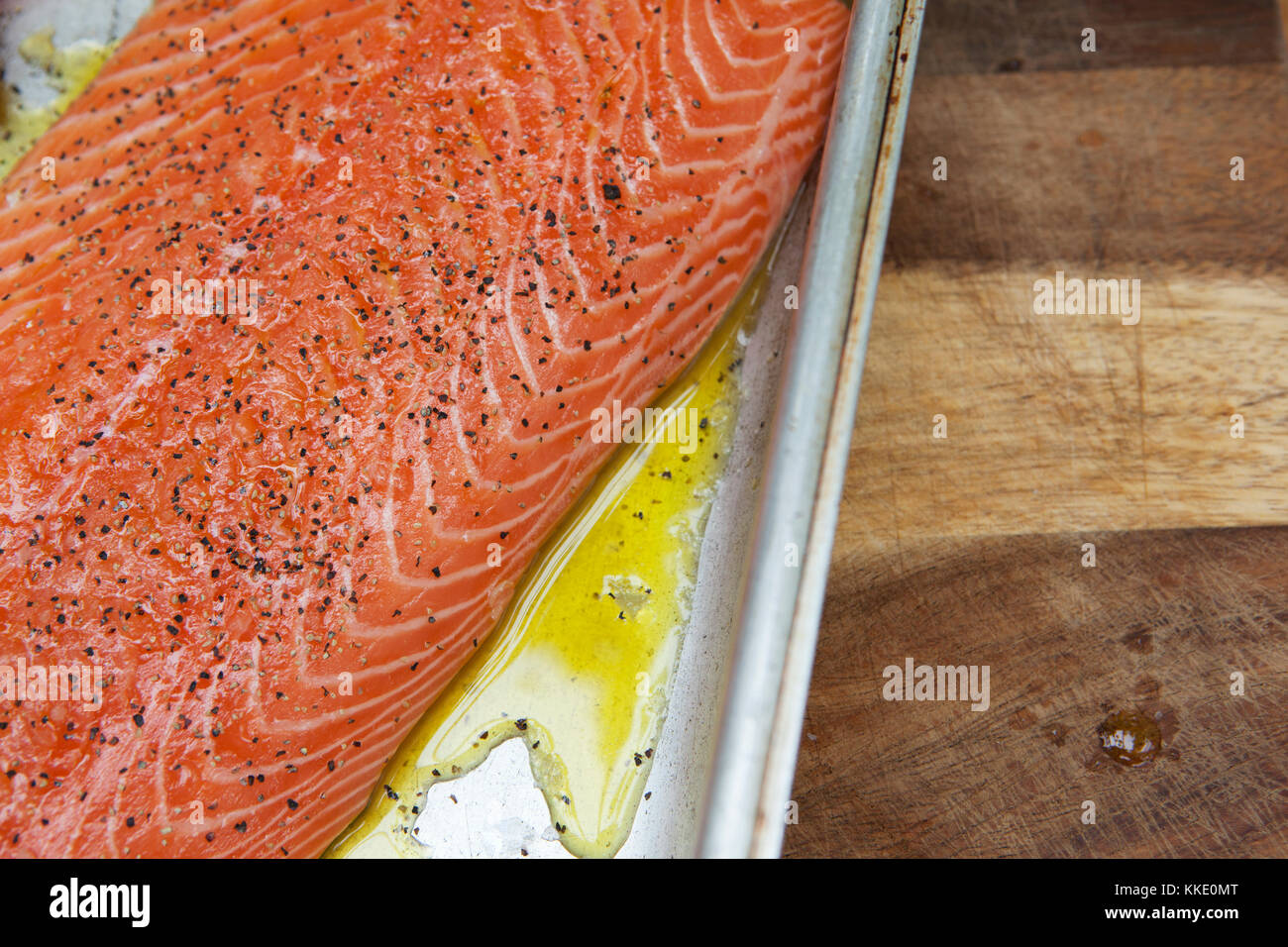 Un lato del salmone in un metallo vassoio di cottura stagionato e in attesa di essere cotti Foto Stock